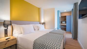 Una habitación de hotel con una cama grande, lámparas de noche, un televisor y un armario.