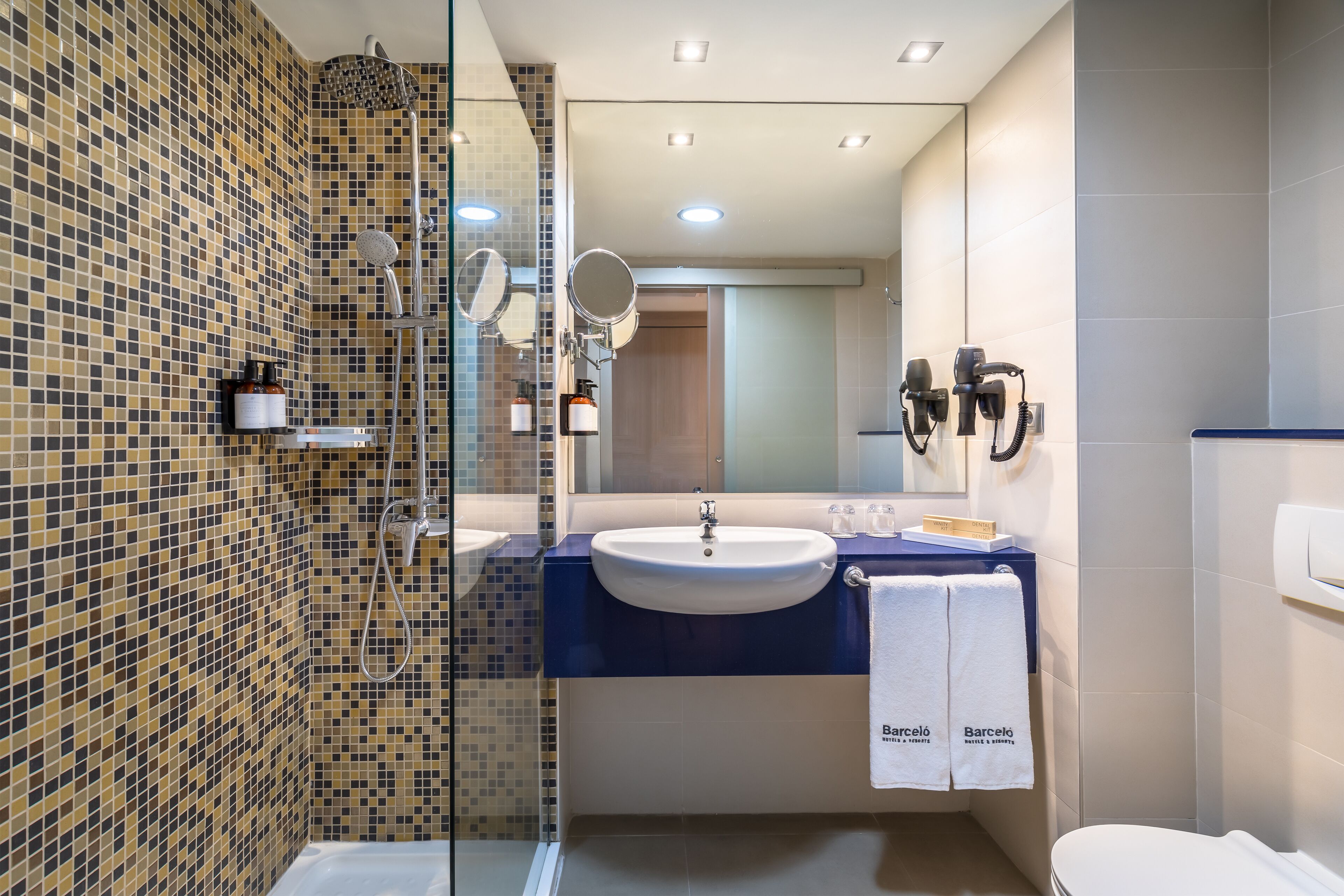 A modern bathroom with a shower, a sink, and a toilet.