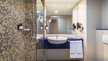 A modern bathroom with a shower, a sink, and a toilet.