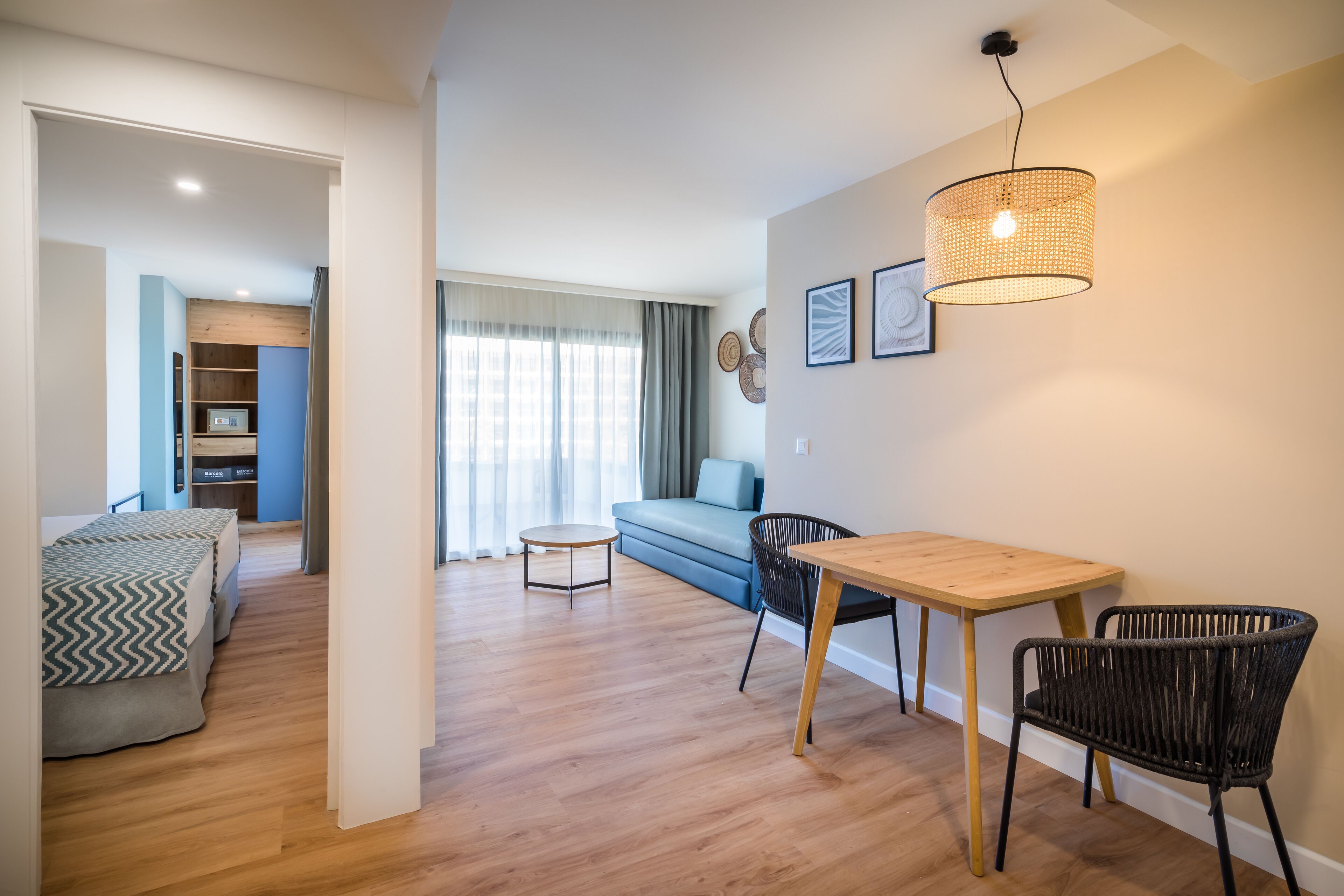 Una sala de estar moderna con un sofá, una mesa de comedor con sillas y una pequeña mesa redonda.