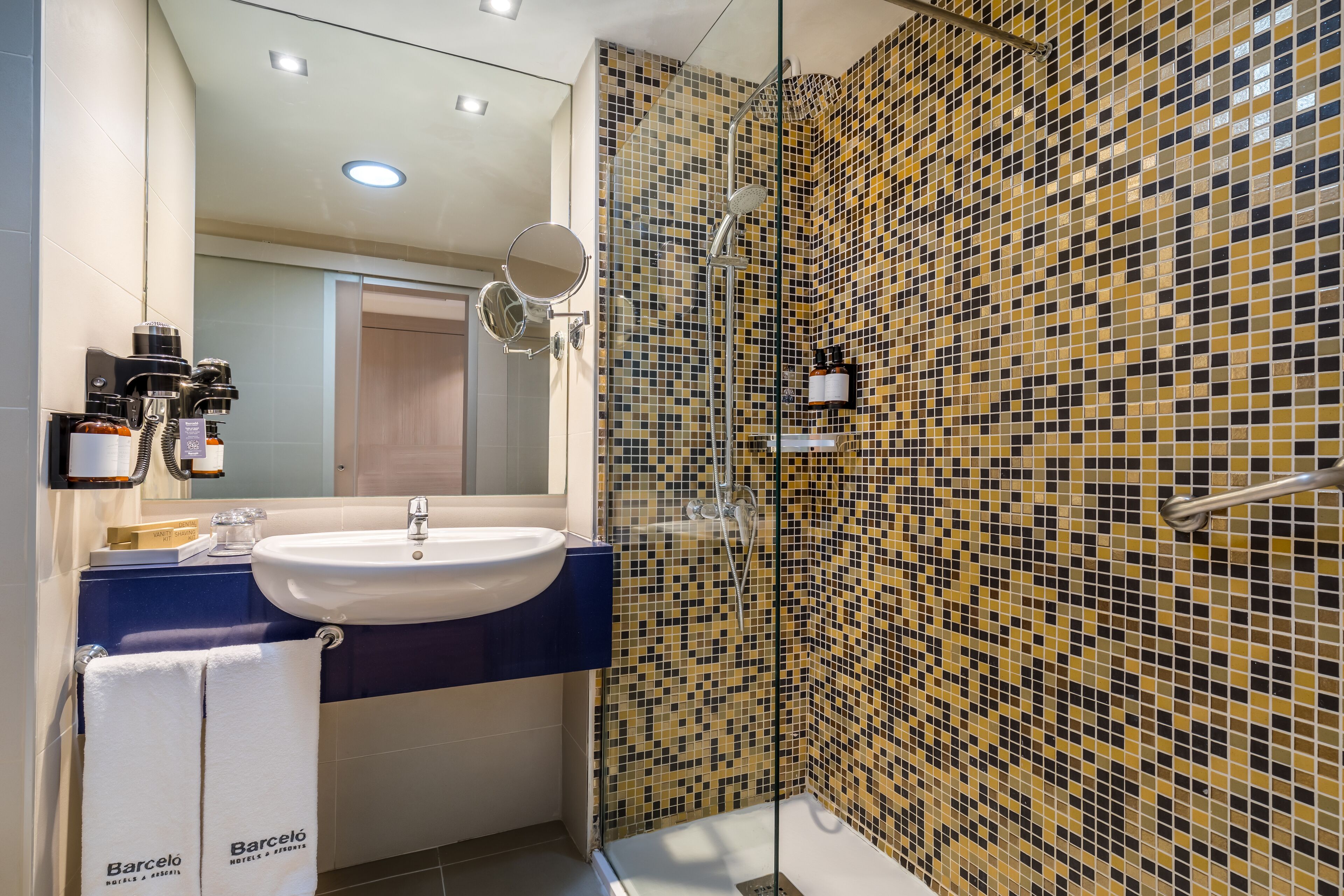 A modern bathroom with a sink, mirror, and shower.