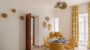 Comedor con una mesa redonda, sillas amarillas y piso de madera.