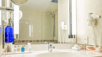 Un baño moderno con lavamanos doble, un espejo grande, un secador de pelo y un perchero para toallas.