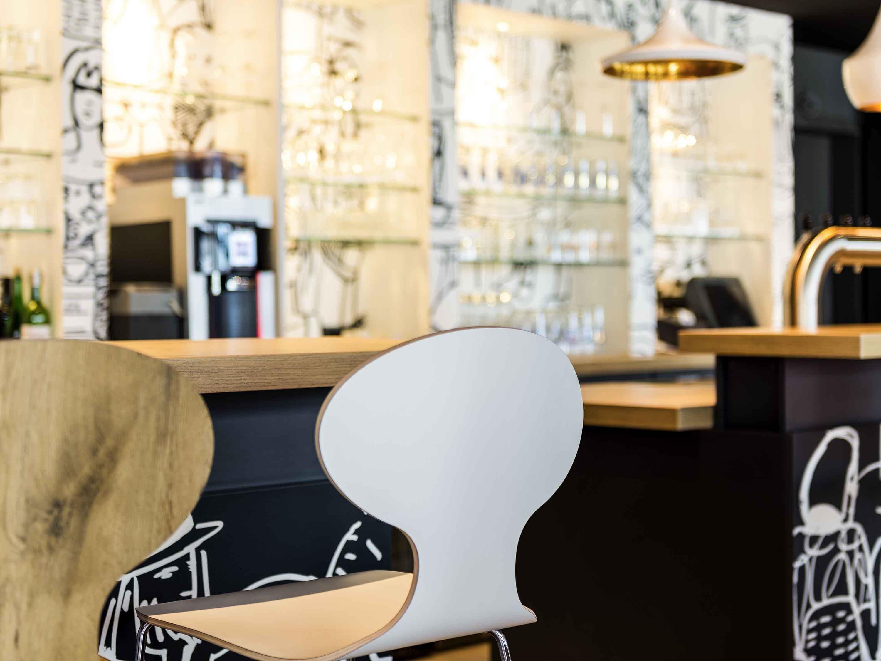 Eine Bar mit Theke, einem Stuhl und einer Wand mit Regalen.