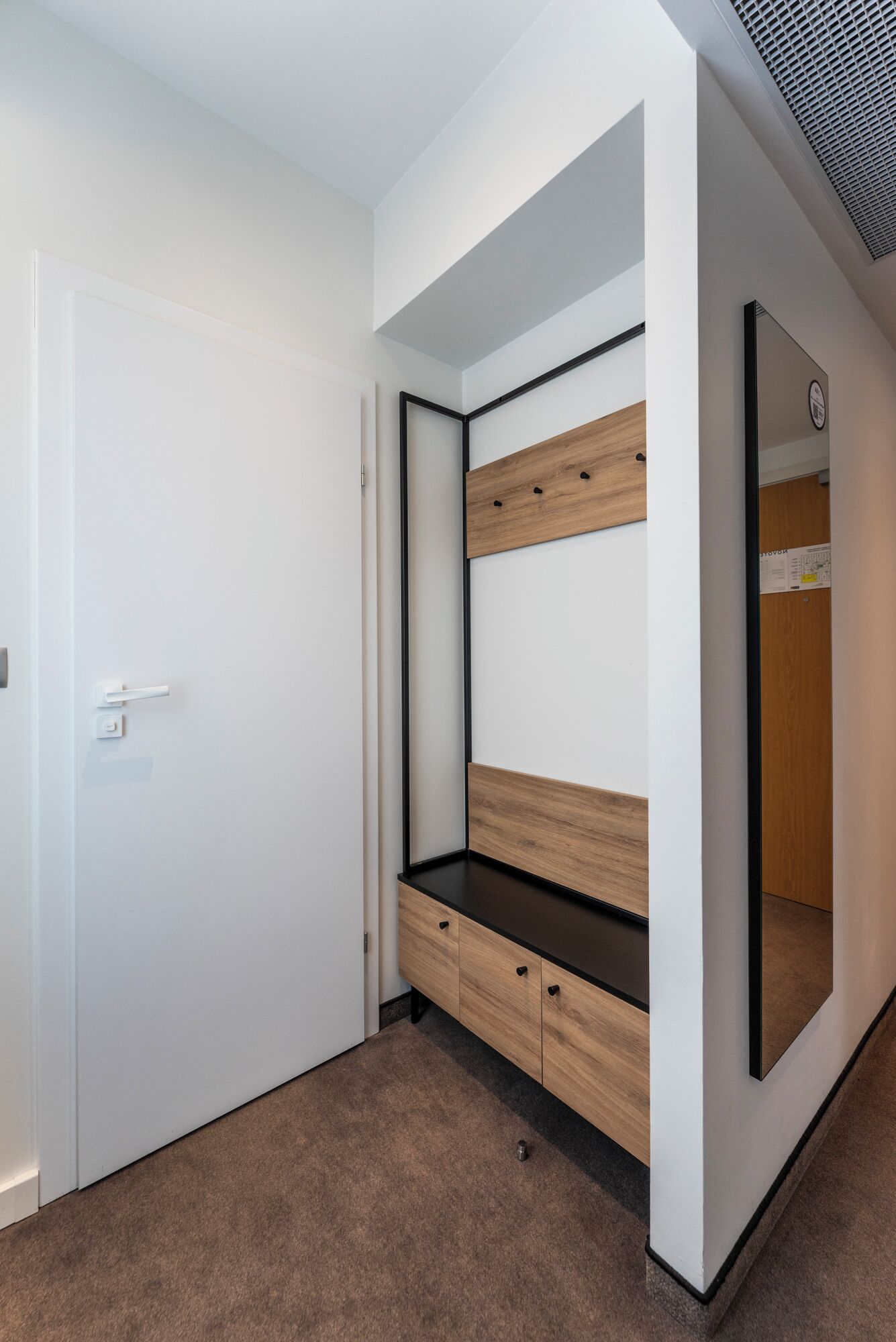 Un dormitorio con cama empotrada, armario y espejo.