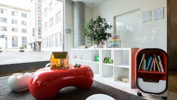 Enjoy a city view from the large window, with a cozy reading nook and a playful touch from the colorful toy house.