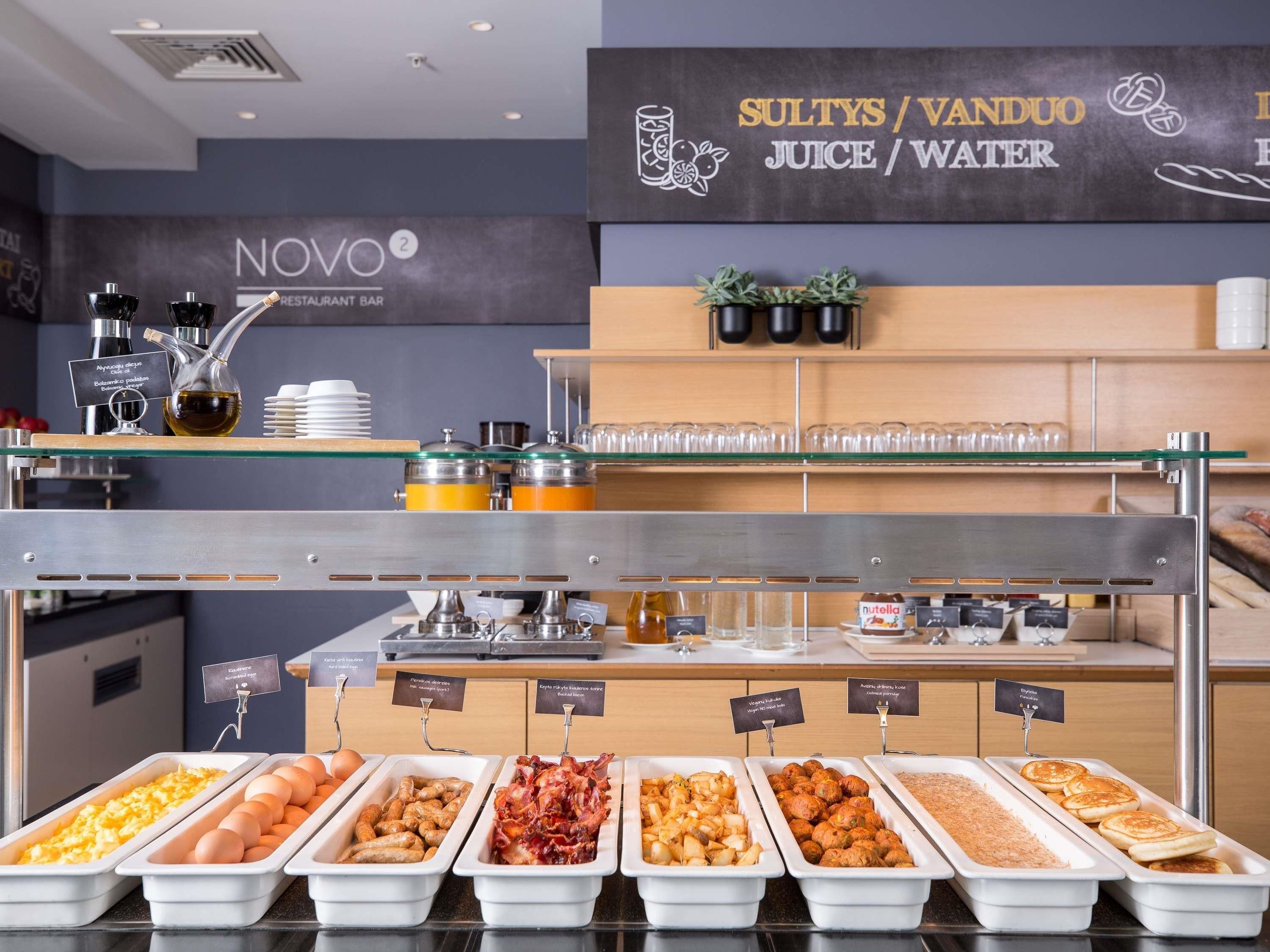 A buffet area with labeled food containers, a water station, and a juice/water sign.