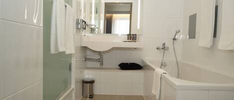 Un baño moderno con cabina de ducha de vidrio, lavamanos blanco y bañera.