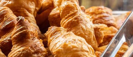 A display of golden-brown croissants in a bakery.