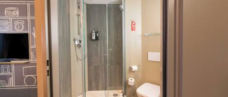 A modern bathroom with a glass-enclosed shower, a toilet, and a sink.
