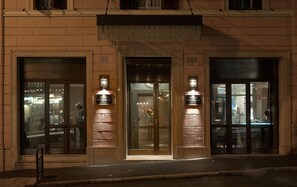Entrada de hotel con puertas de vidrio, números 112 y 113, y se ve el interior a través del vidrio.