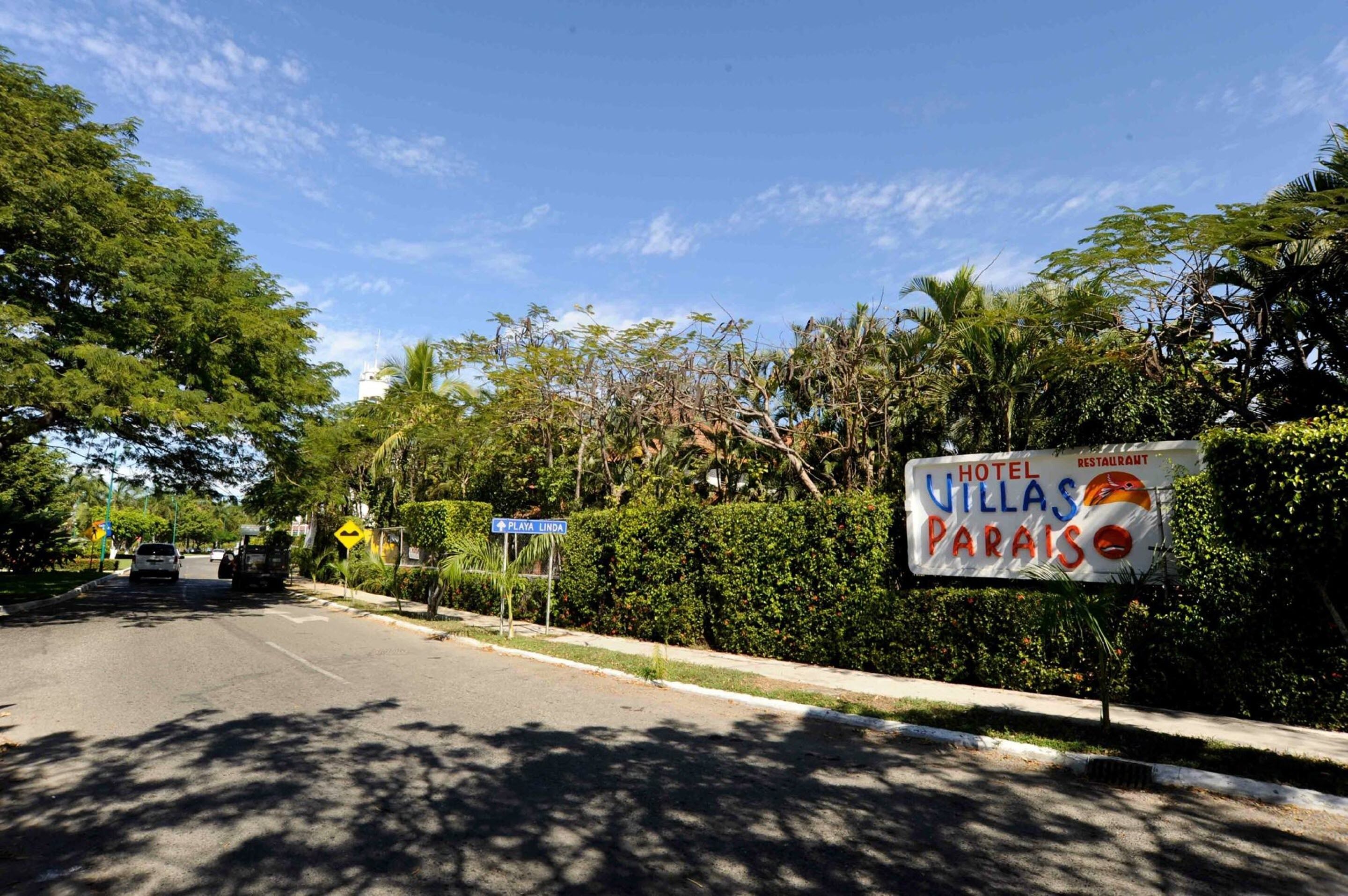 Señal de carretera para Hotel Villas Paraíso, con fondo azul y texto blanco.