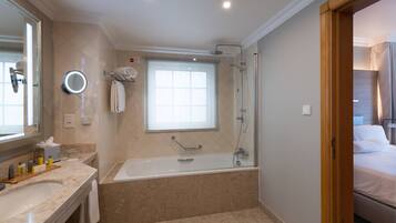 A modern bathroom with a large bathtub, a shower, and a vanity with a mirror.