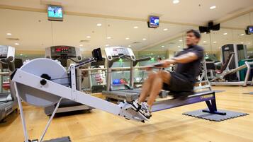 Un gimnasio con equipo de ejercicio, incluyendo una máquina de remo y cintas de correr.