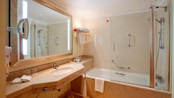 Un baño moderno con ducha de vidrio, un espejo grande y un lavabo de mármol.