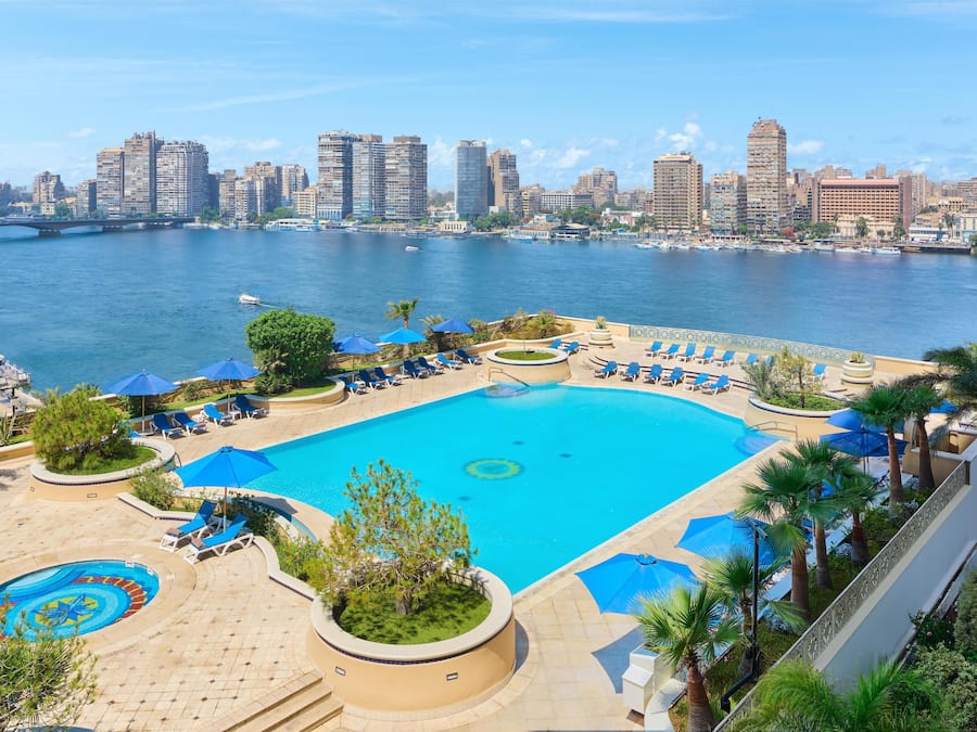 Una piscina al aire libre, sillones reclinables de piscina