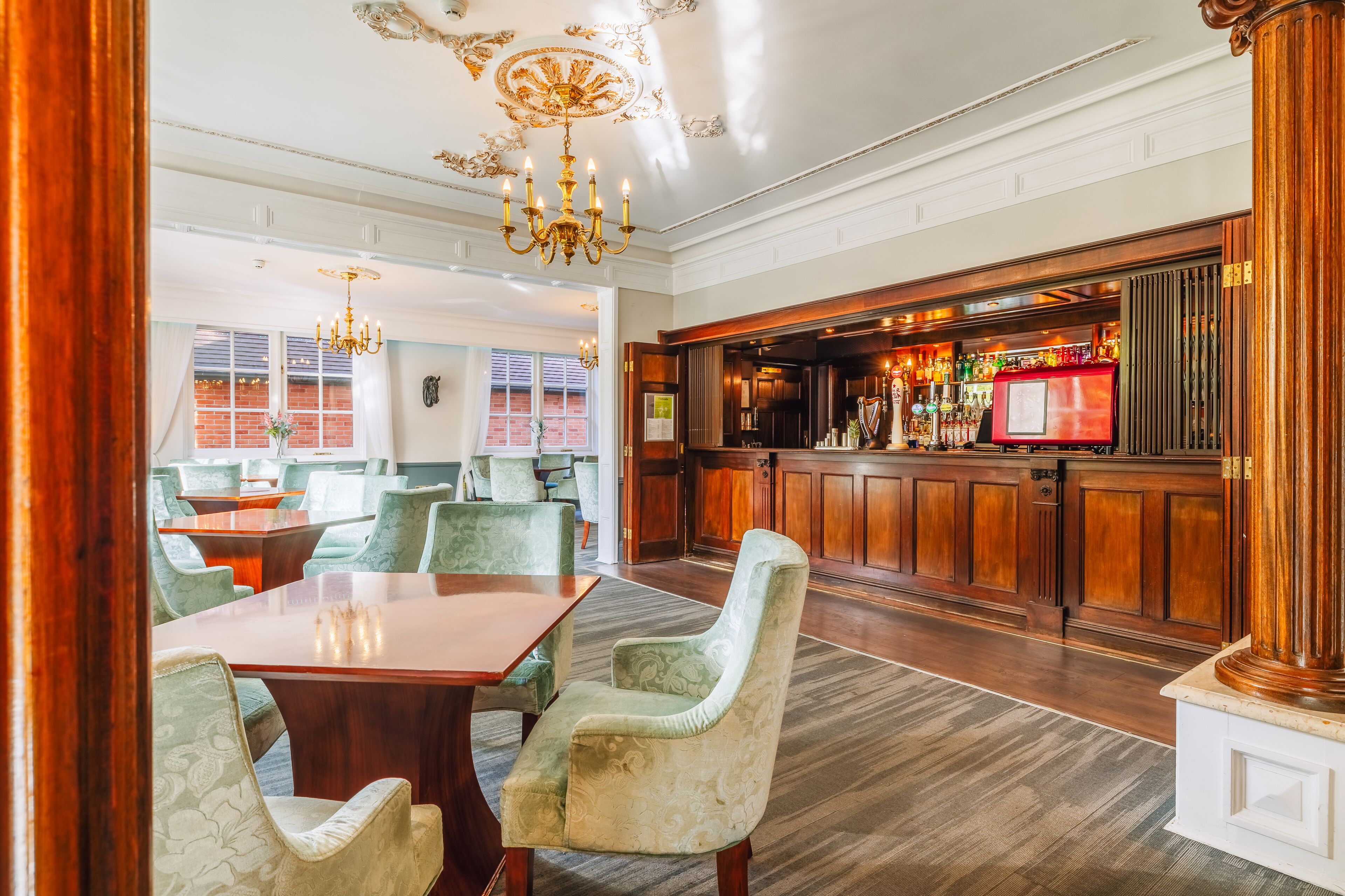 A spacious lobby with a bar area, comfortable seating, and a chandelier.