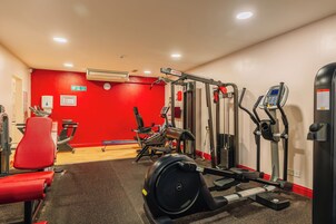 A gym with various exercise equipment, including treadmills, stationary bikes, and weight machines.