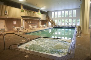 An indoor swimming pool with a hot tub, seating area, and a staircase to an upper level. - Sandwich Lodge & Resort (Sandwich)