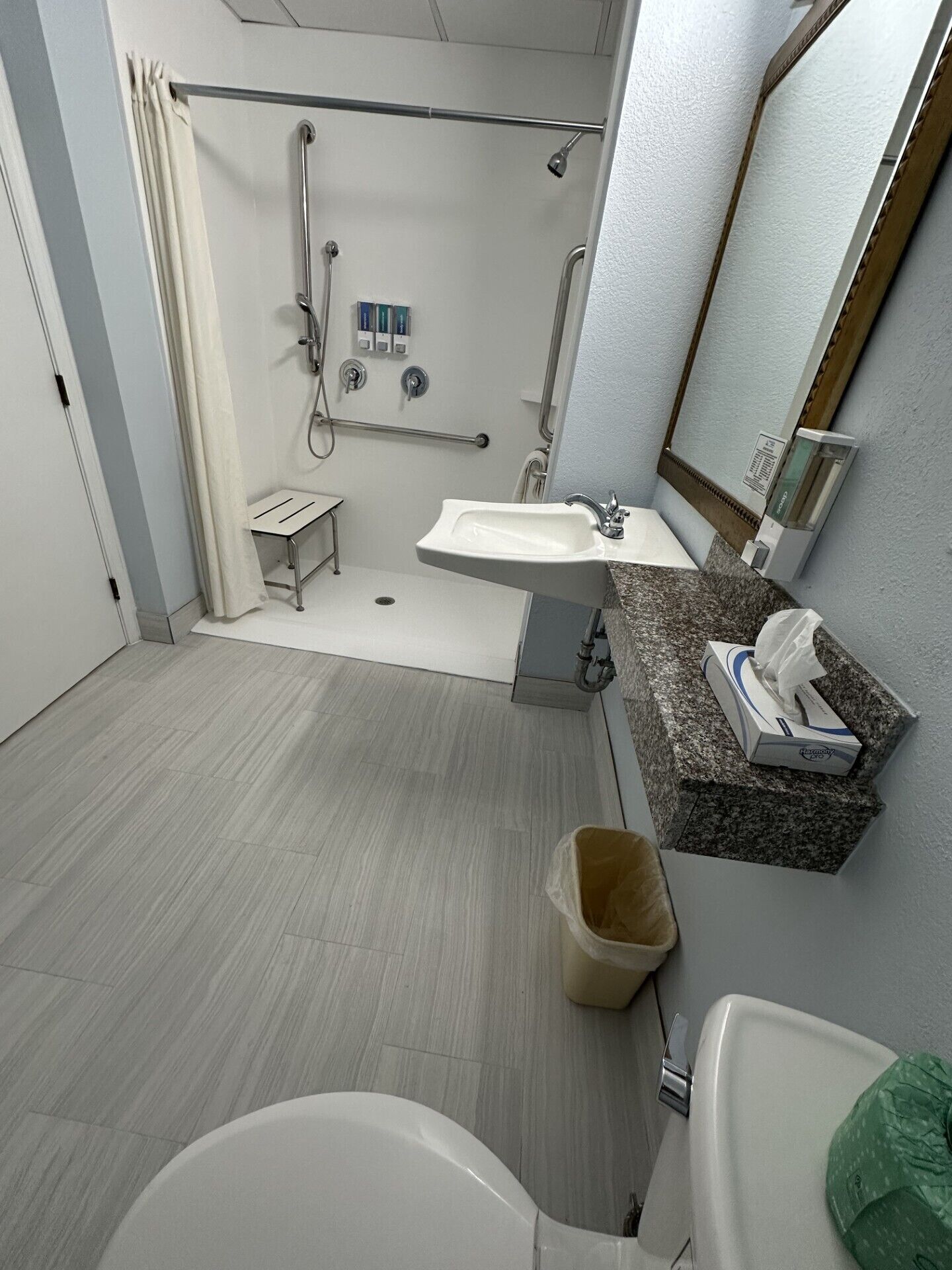 A modern bathroom with a shower, sink, and toilet.