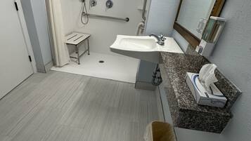 A modern bathroom with a shower, sink, and toilet.