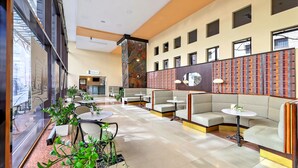 Un hall amplio con zonas de estar, un mostrador de recepción y una pared con diseño.