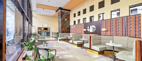 Un hall amplio con zonas de estar, un mostrador de recepción y una pared con diseño.
