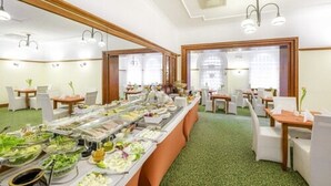 A buffet setup with various food items and a green carpeted floor. - Hotel Hetman (Warsaw)