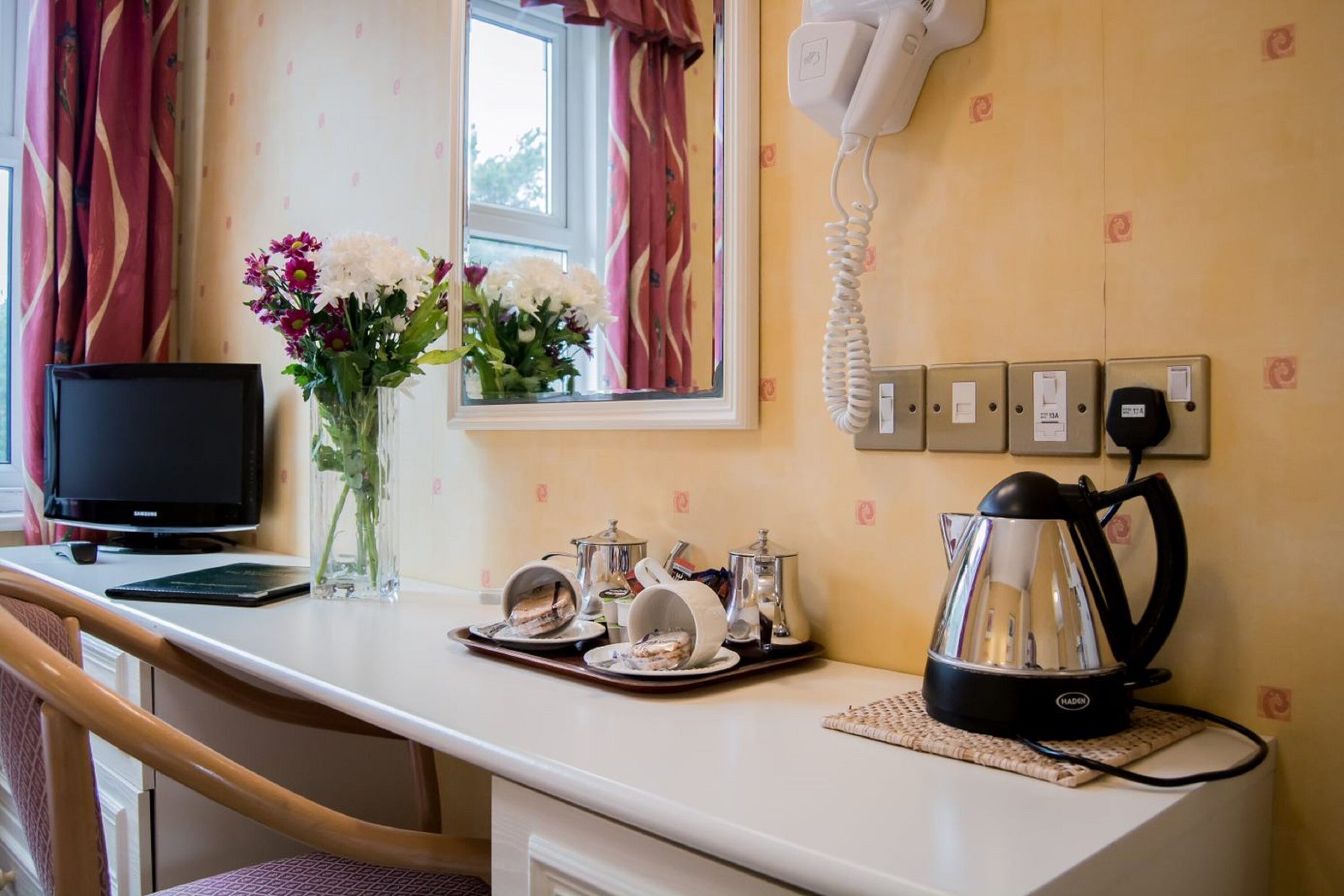 desk, iron/ironing board, bed sheets, alarm clocks