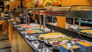Un bufé con diferentes opciones de comida, incluyendo frutas, verduras y productos lácteos.
