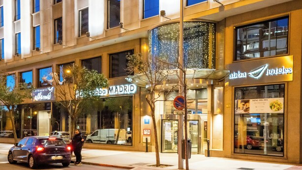 Fachada de hotel con letreros que indican 'Abba Madrid' y 'Abba Hotels'.
