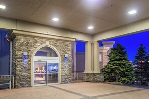A hotel entrance with a stone facade, a glass door entrance, and a Christmas tree. - Holiday Inn Express Wisconsin Dells by IHG (Baraboo)