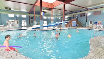 An indoor swimming pool with multiple lanes, a slide, and a play area.
