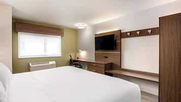 Une chambre d’hôtel avec un lit, un bureau, une télévision et une fenêtre.