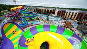 A water park with multiple slides and pools, surrounded by a hotel with multiple floors and balconies. - Holiday Inn Express Wisconsin Dells by IHG (Baraboo)