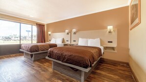 A hotel room with two beds, a large window, and a view of the parking lot. - River Valley Motor Inn (La Grange)