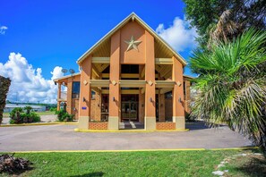 A building with a star on the facade, a covered entrance, and a parking lot.