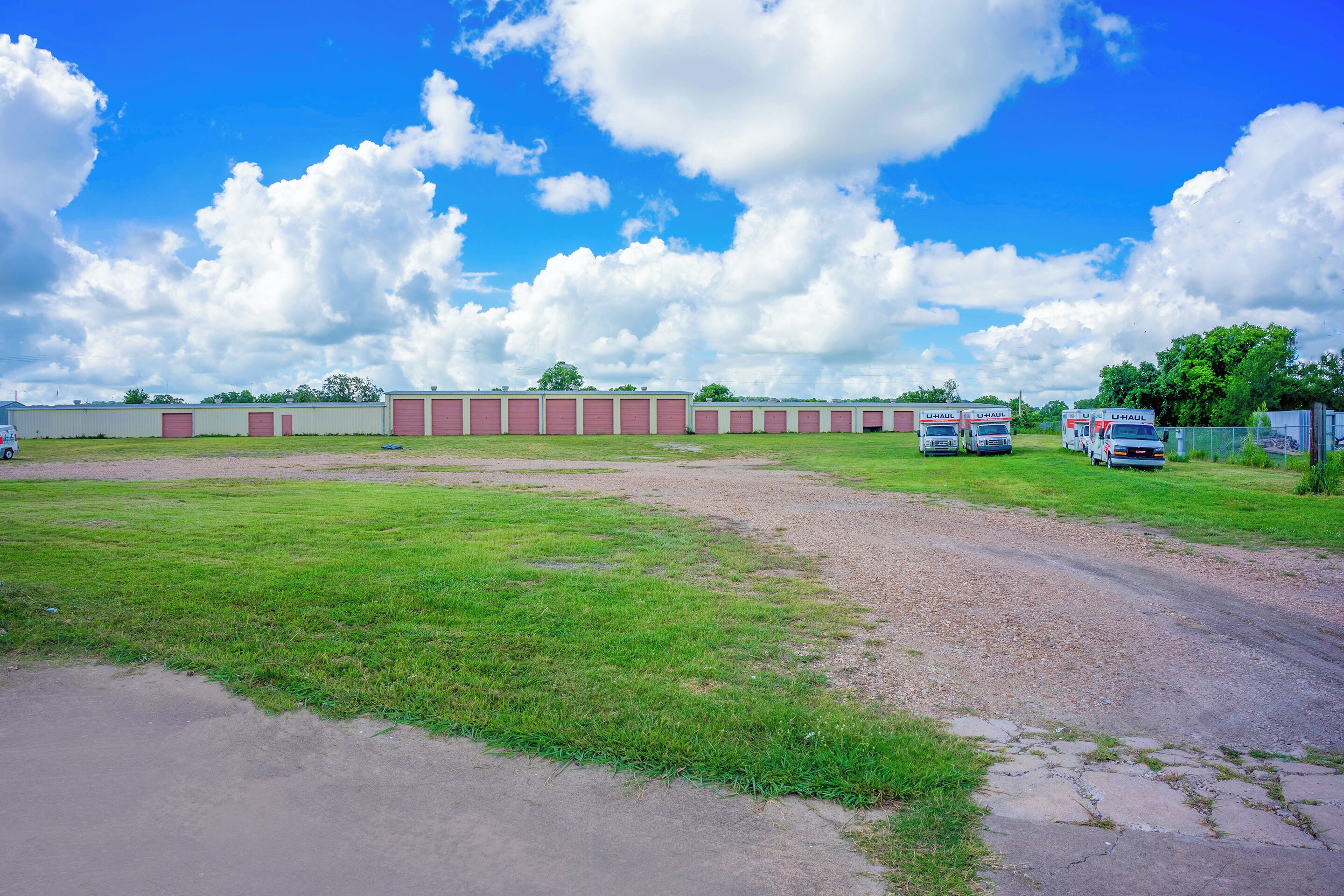 A large industrial area with U-Haul trucks parked in a grassy field.
