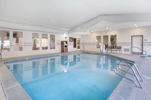 Una piscina techada, sillones reclinables de piscina