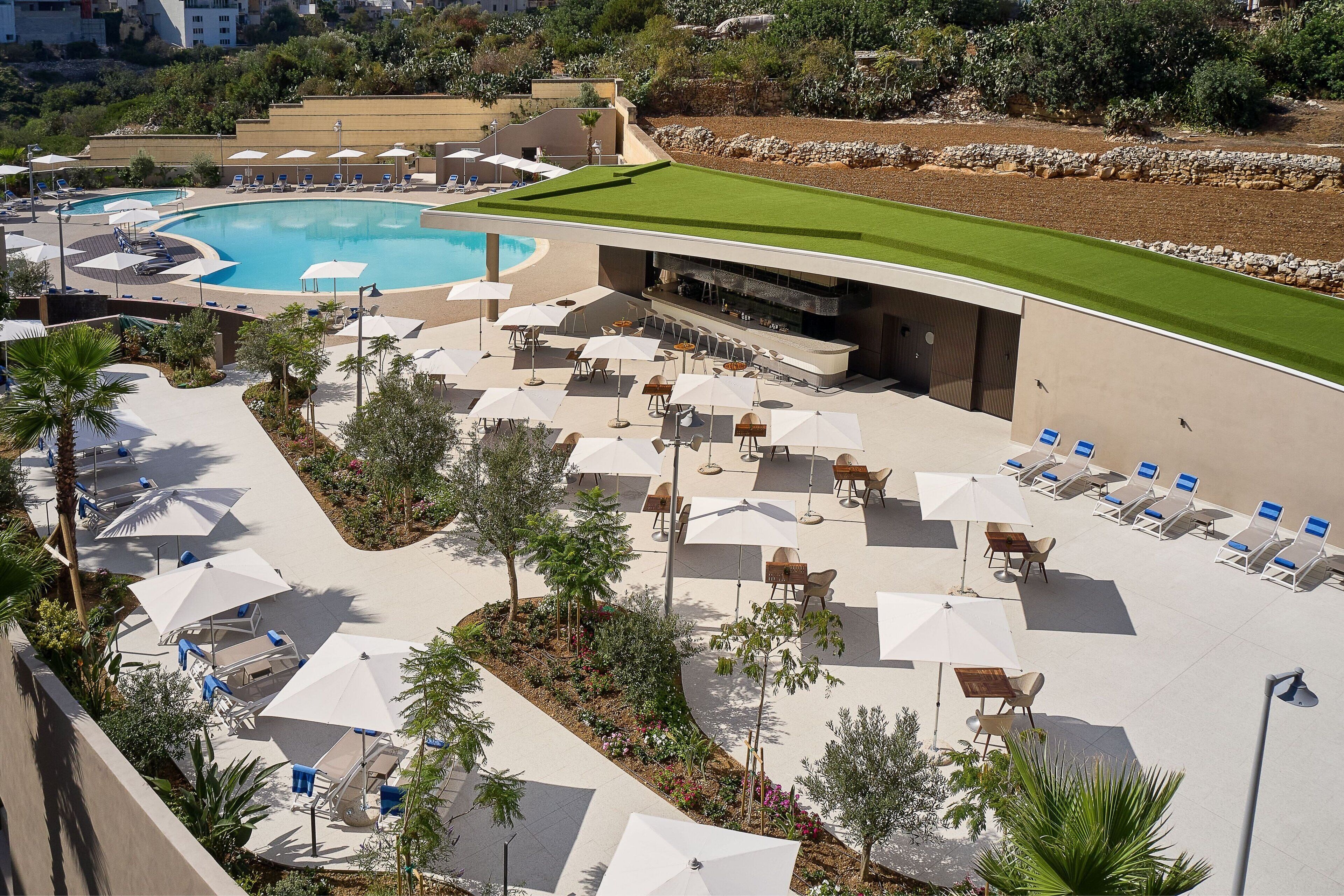 A resort with a pool, lounge areas, and a bar.