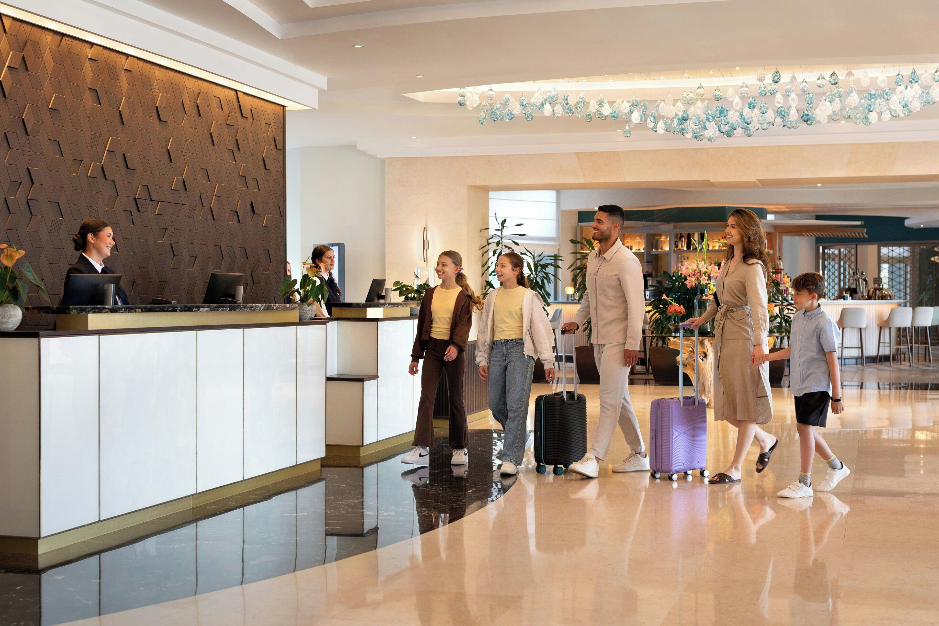 A hotel reception area with a modern design, a reception desk, and a waiting area with seating.