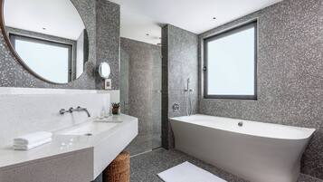 A modern bathroom with a freestanding bathtub, a large mirror, and a sink with a countertop.