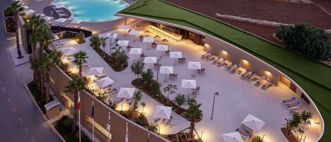 Un resort con varias piscinas, tumbonas y sombrillas.
