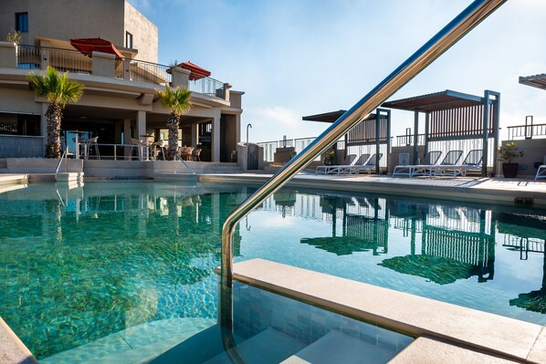 Piscine intérieure, piscine extérieure en saison, chaises longues