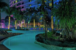 Een buitenzwembad, parasols bij het zwembad en ligstoelen