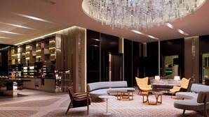 A modern lobby with a bar area, seating arrangements, and a large chandelier. - Le Méridien Kuala Lumpur (Kuala Lumpur)