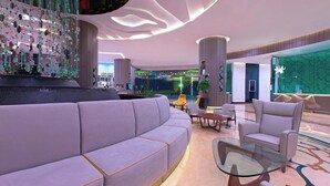 A modern lobby with a curved sofa, a glass coffee table, and contemporary chairs. - Le Méridien Kuala Lumpur (Kuala Lumpur)