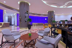 A modern lobby with a reception desk, seating area, and decorative plants. - Le Méridien Kuala Lumpur (Kuala Lumpur)