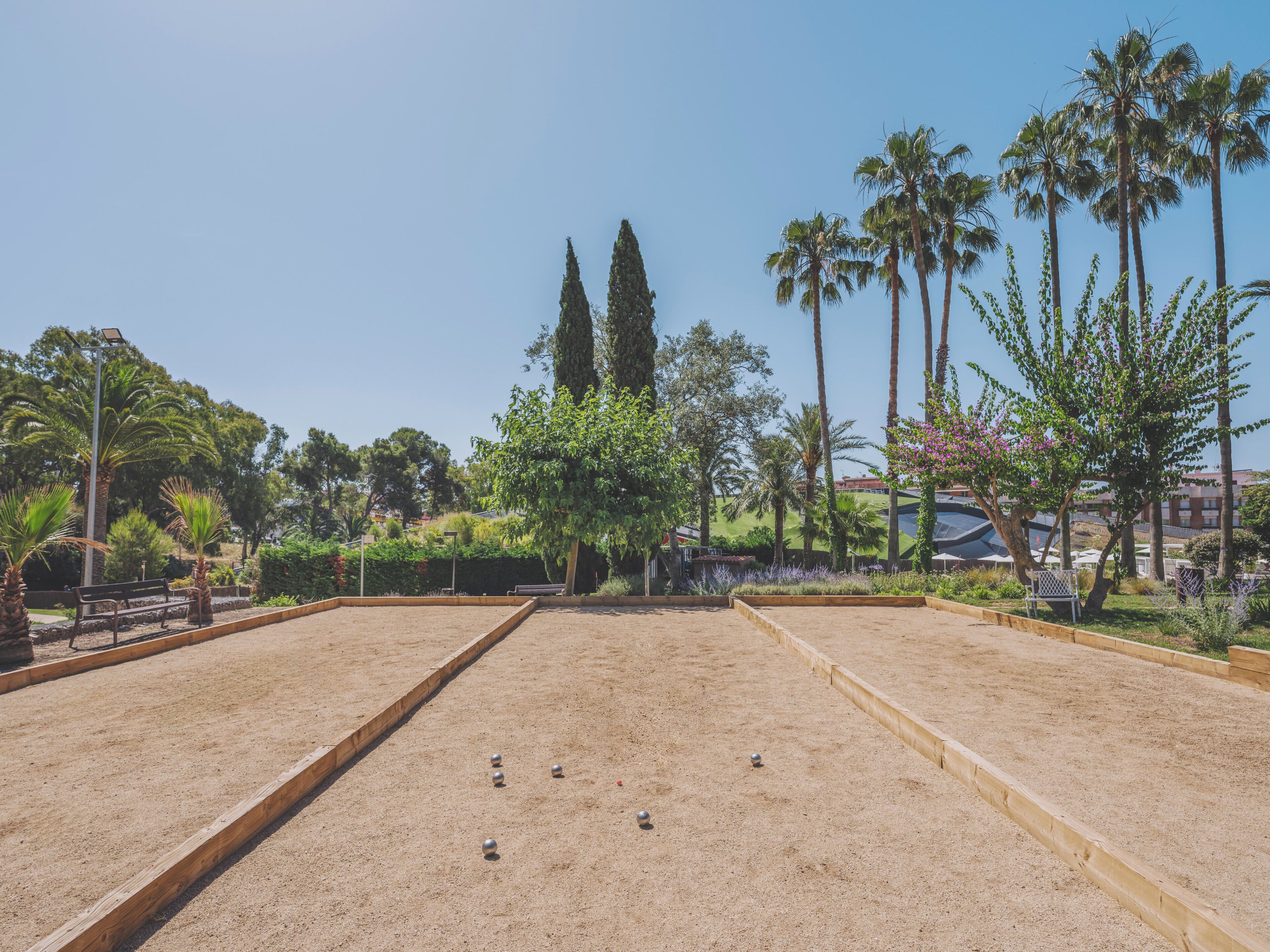 A croquet court with sand courts and surrounding greenery.