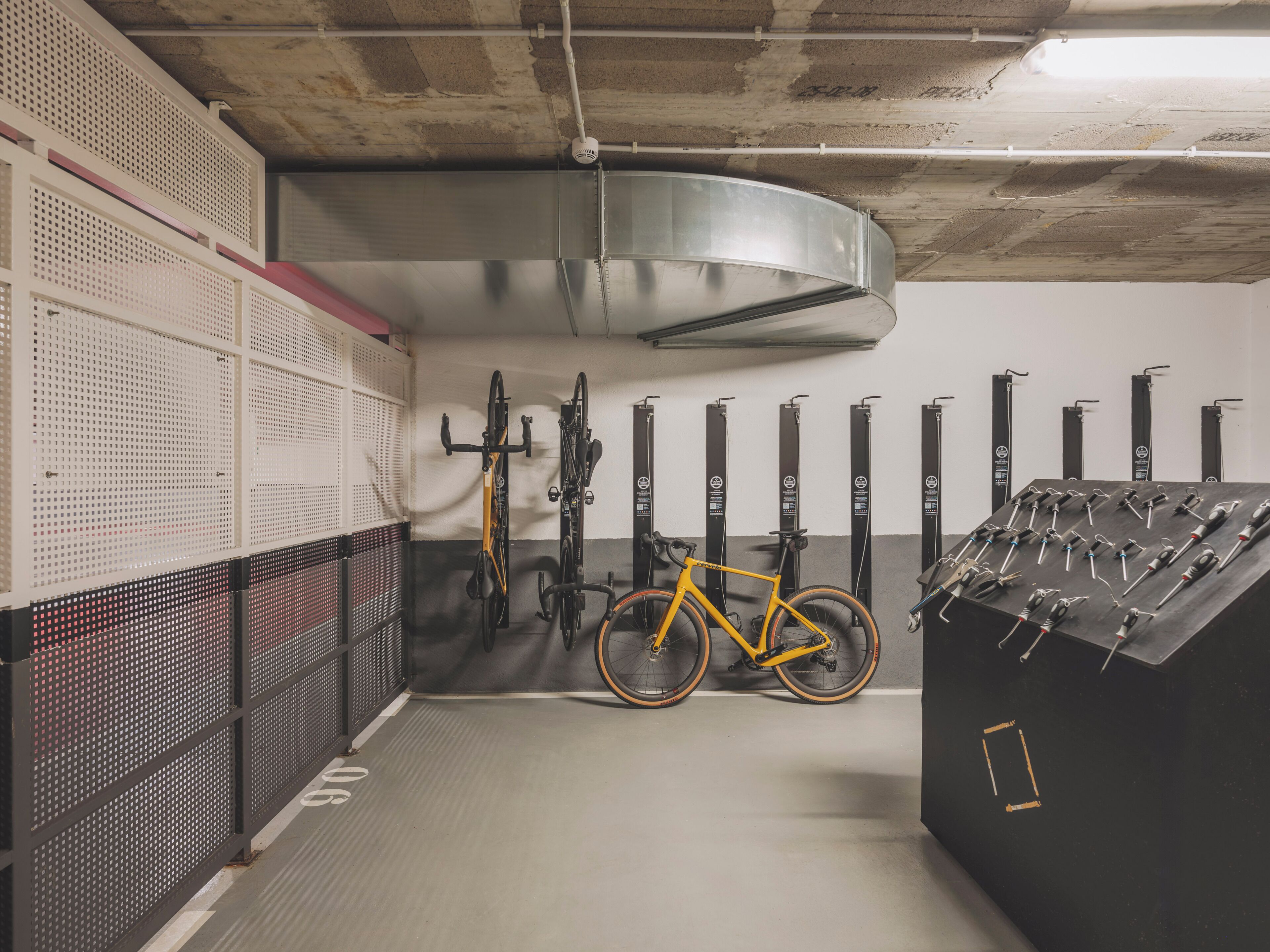 Zona de guardado de bicicletas con varias unidades y un panel de control.
